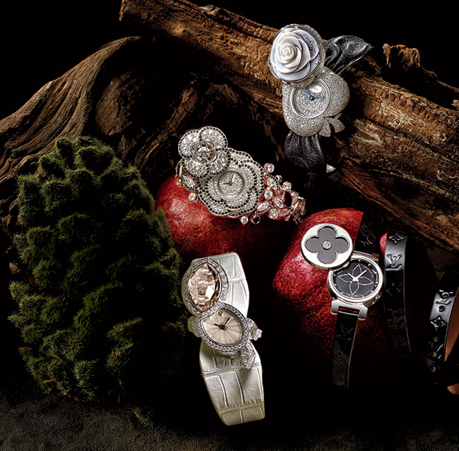 CLOCKWISE FROM TOP: From Breguet, this Secret De La Reine watch ($92,200) features a floral cover created in hand-carved shell cameo. The bow motif, flange, and dial are set with more than four carats of diamonds. It houses a self-winding numbered and signed movement. This Louis Vuitton Tambour Bijou Secret watch ($6,150) is crafted in steel for an affordable secret. It features a Monogram flower cover set with diamonds. From Cartier, this 18k white-gold Tortue Secret watch ($97,000) is designed in the likeness of a turtle, with diamonds and green sapphires as the turtle’s eyes. A large faceted morganite gemstone serves as the dial cover and the turtle’s shell. Chanel, this Camélia Gansé watch ($252,000) is rendered in 18k white gold and set with roughly 16 carats of diamonds (marquise-and brilliant-cut) and black spinels. PHOTO by Jeff Crawford